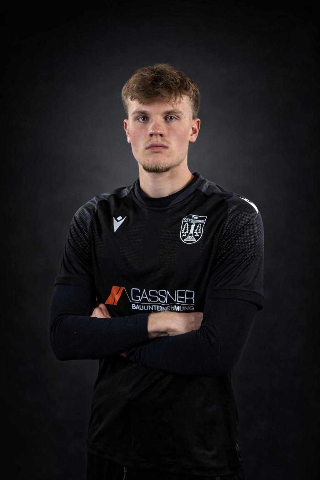 Porträt von Elias Adelberg, Torhüter und Jugendtorwarttrainer des TSV Ottobrunn, im schwarzen Torwarttrikot